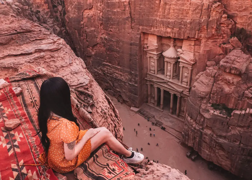 A girl at a tea shop with a view of the treasury in petra in jordan