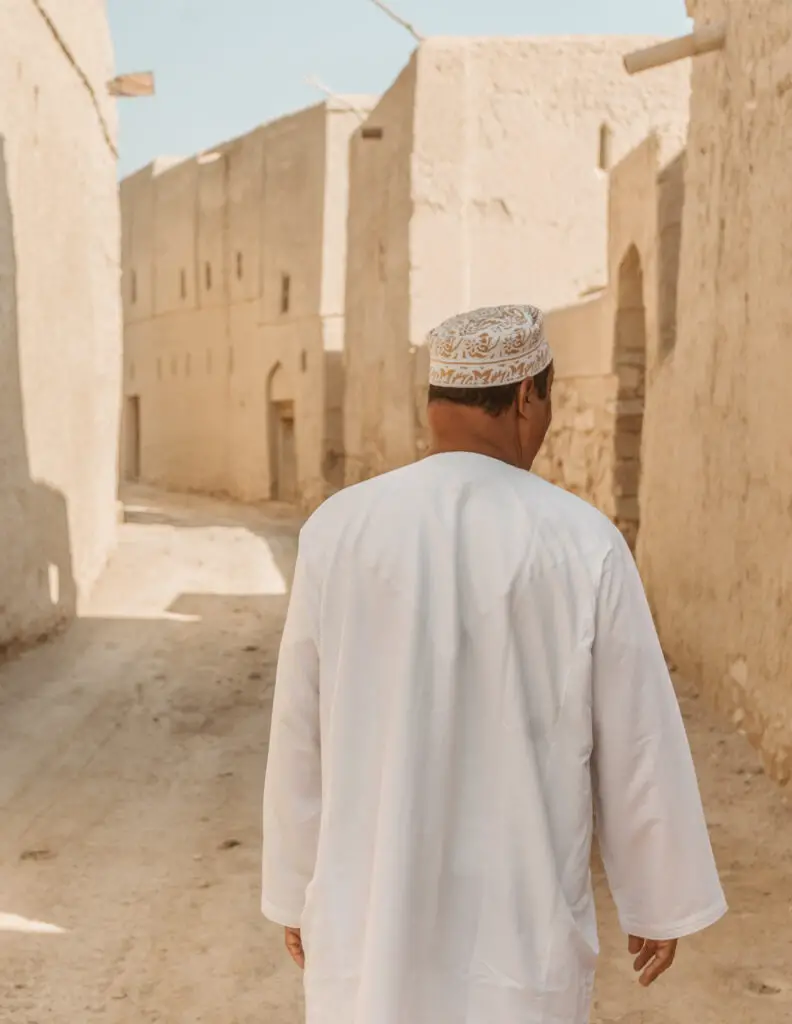 an omani man in a historic village made of mud