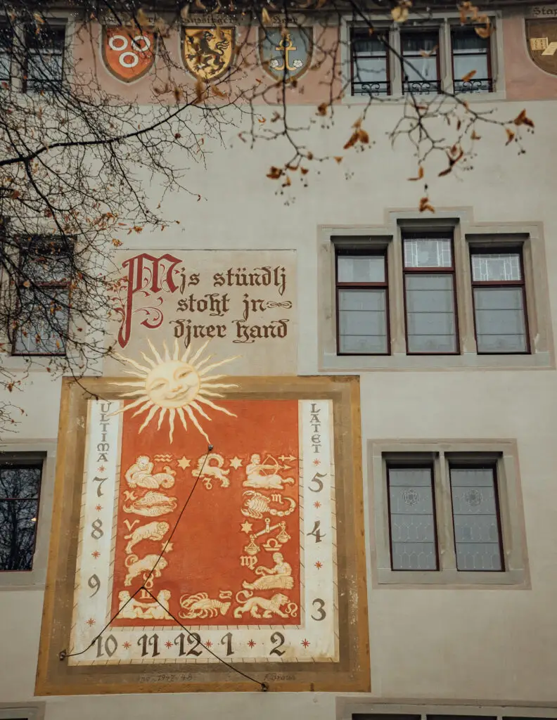 german words on a wall with artwork of a sun and star signs in rapperswil