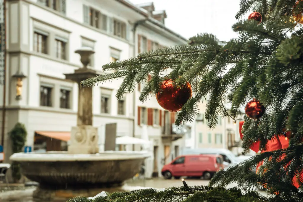 christmas tree and decorations in the old town square of rapperswil in the snow