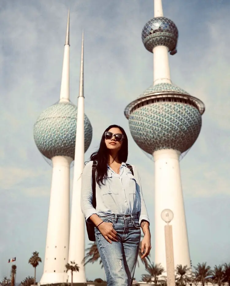 a girl in front of kuwait towers