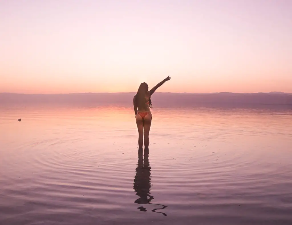 a girl in the dead sea at sunset in jordan