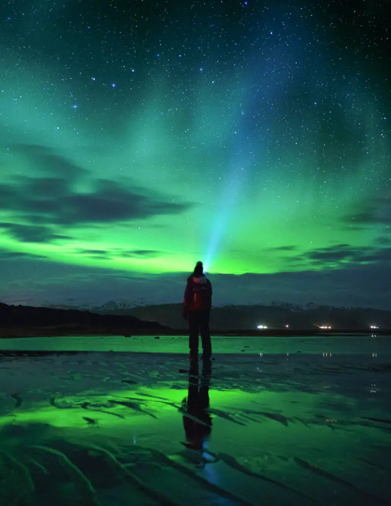 man looking at northern lights in iceland