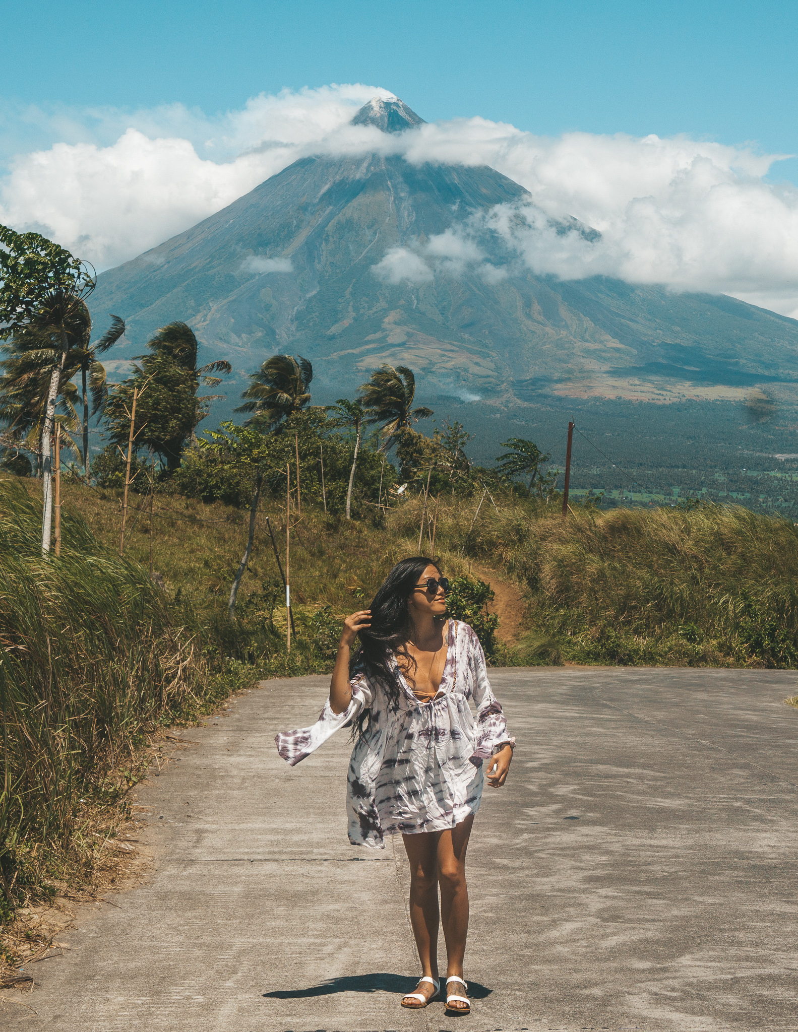 a girl standing in front of mount mayon a very active volcano near legazpi in the albay province of the philipines