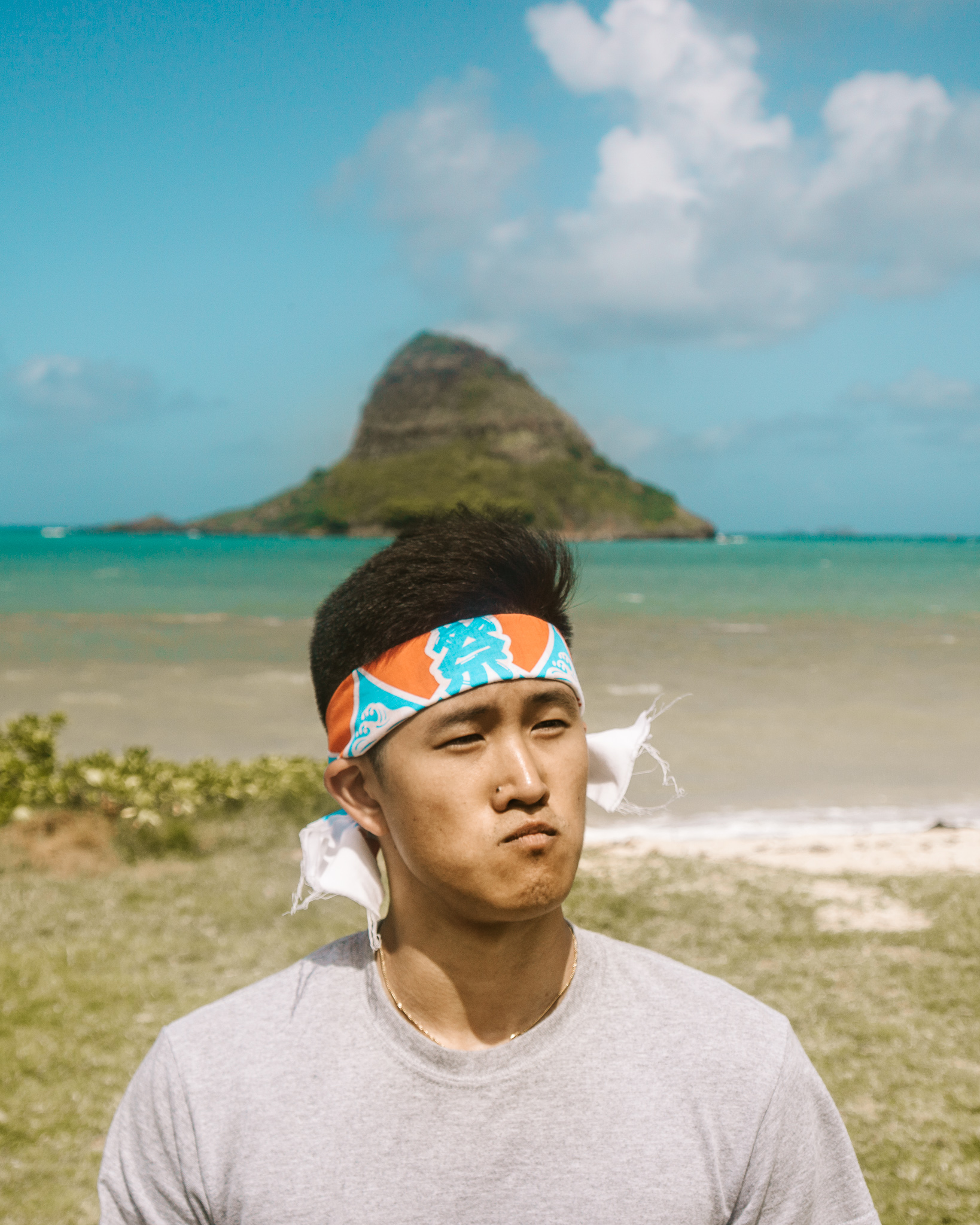 a man with china man's hat island behind him on oahu