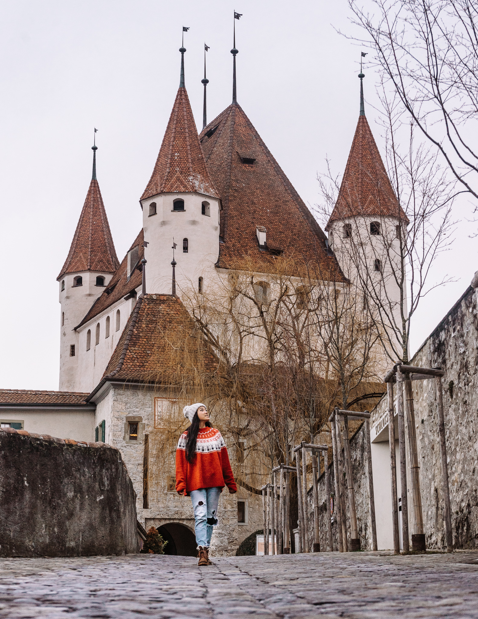 A woman in a red Christmas sweater in front of Thun castle in Thun in switzerland