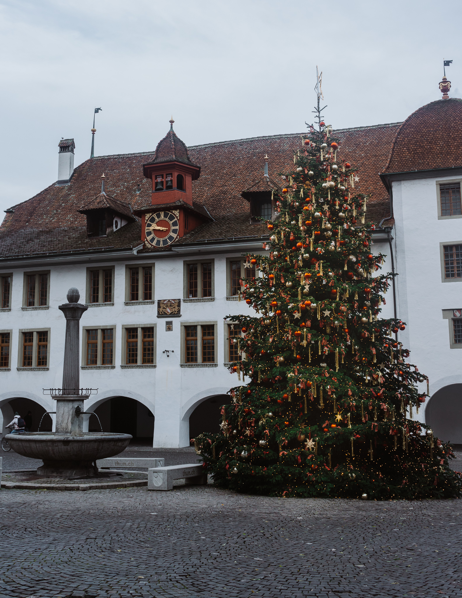 Thun old town with a white town hall in the background and a Christmas tree in Switzerland in winter