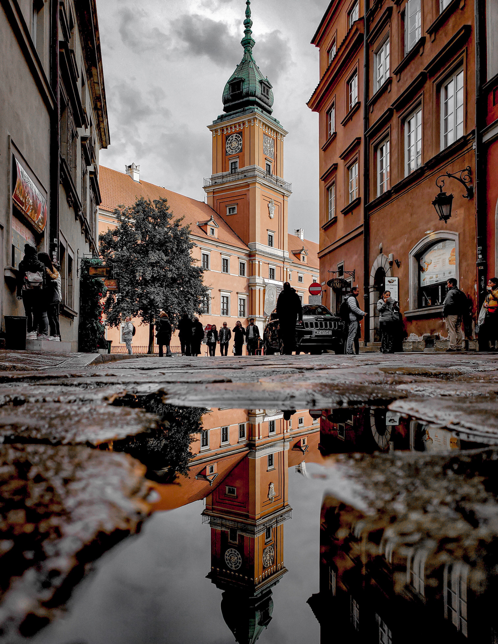 a view of warsaw old town reflected in a puddle in poland
