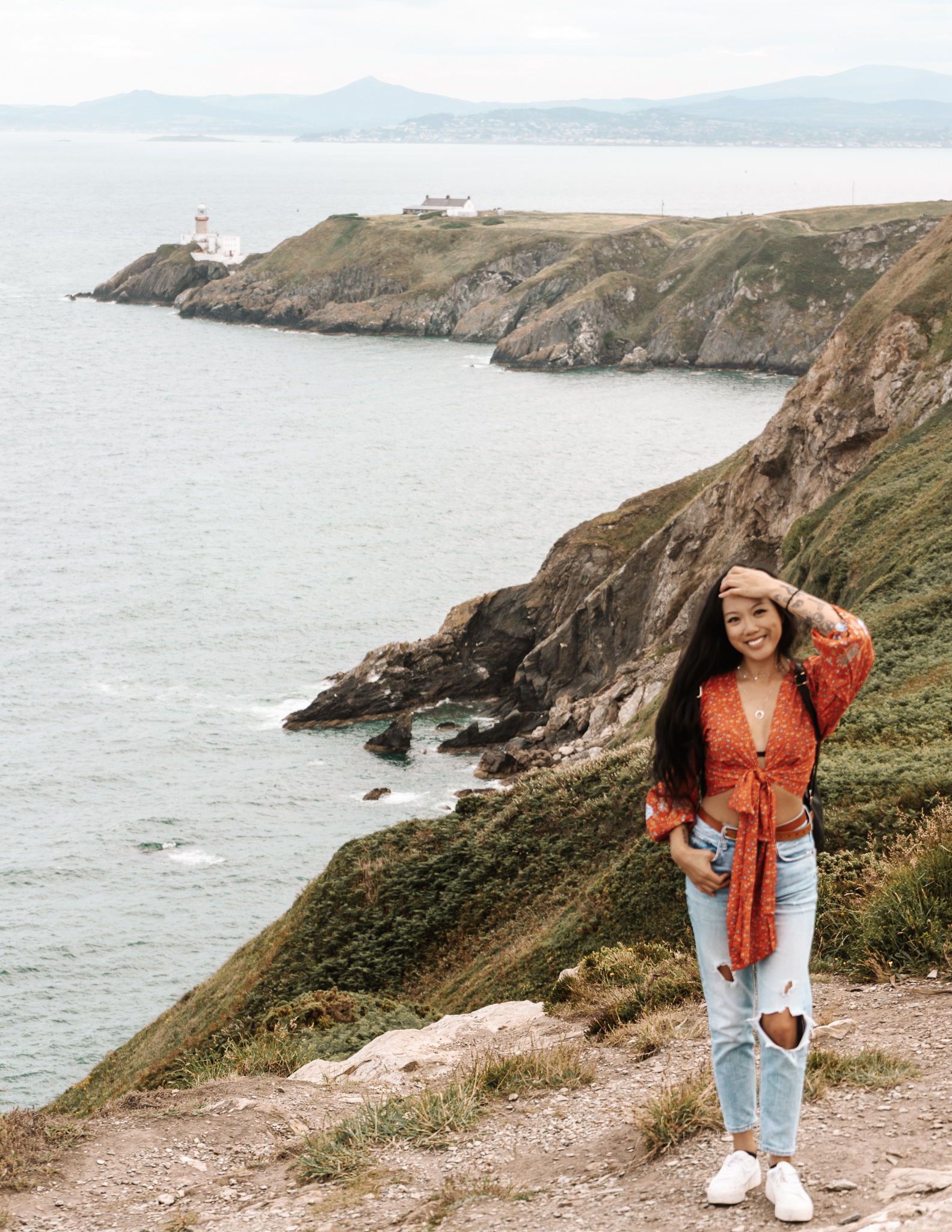 a digital nomad in ireland standing at the cliffs in howth