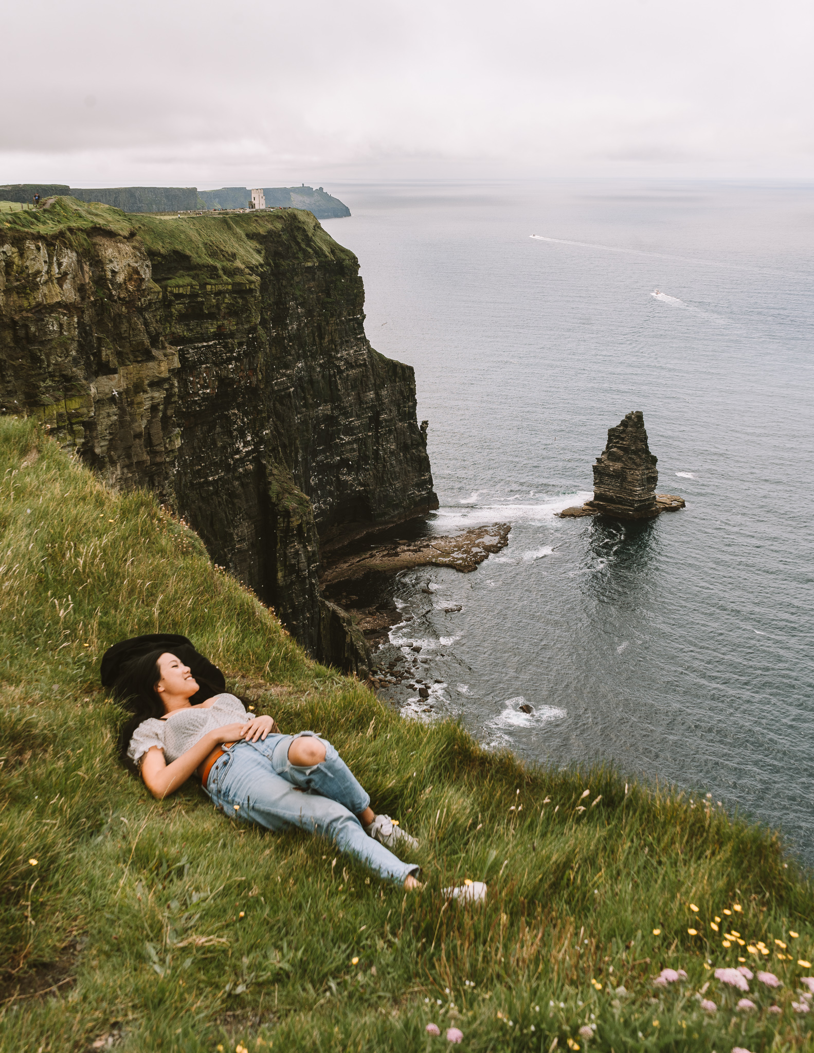 a digital nomad in Ireland taking a nap along the cliffs of Moher