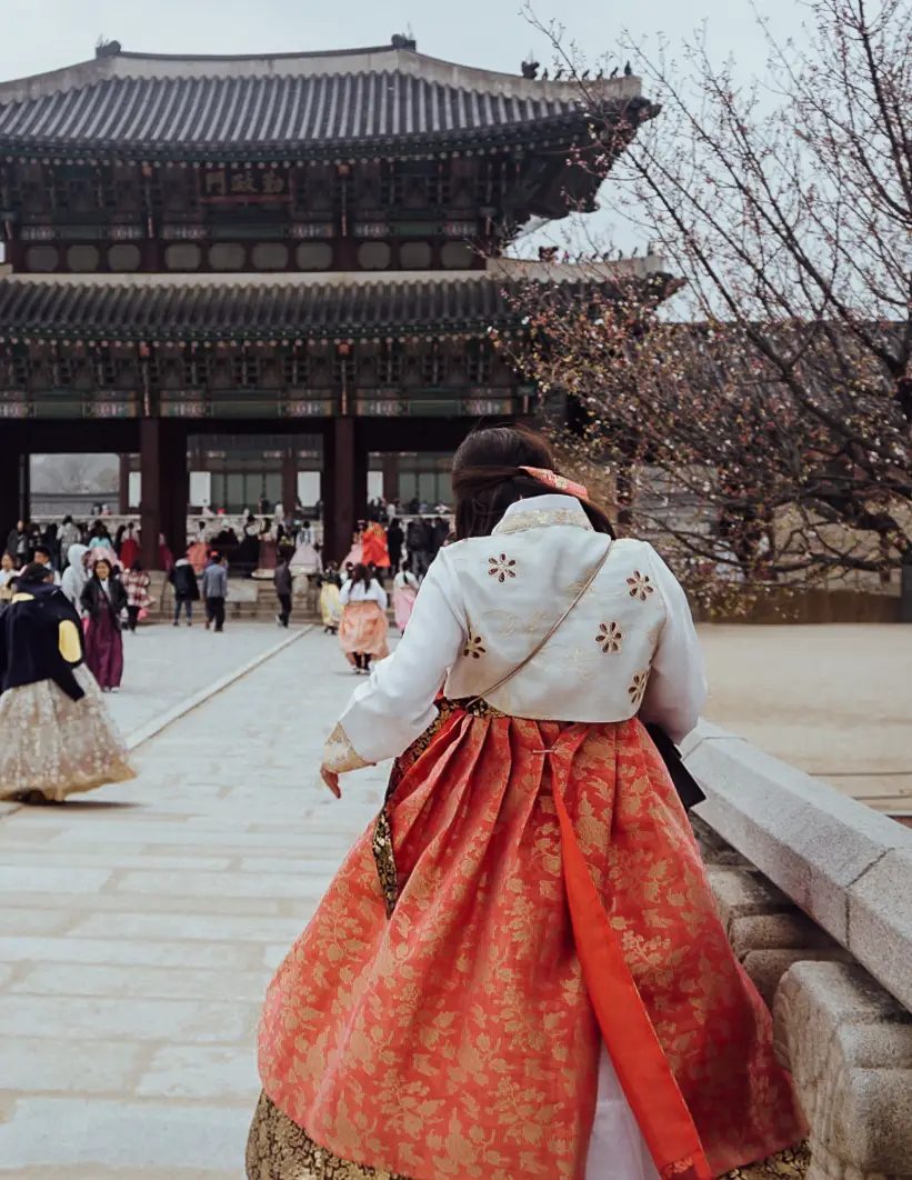 a girl wearing a red hanbok dress in seoul south korea