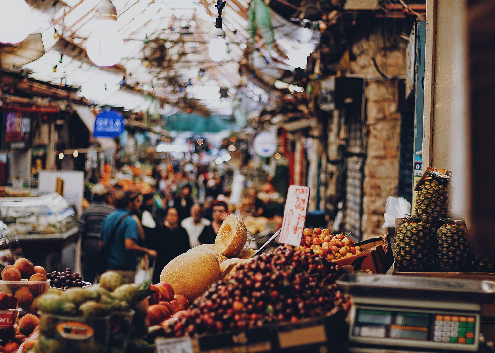 a busy street with outdoor markets selling fruit in Israel