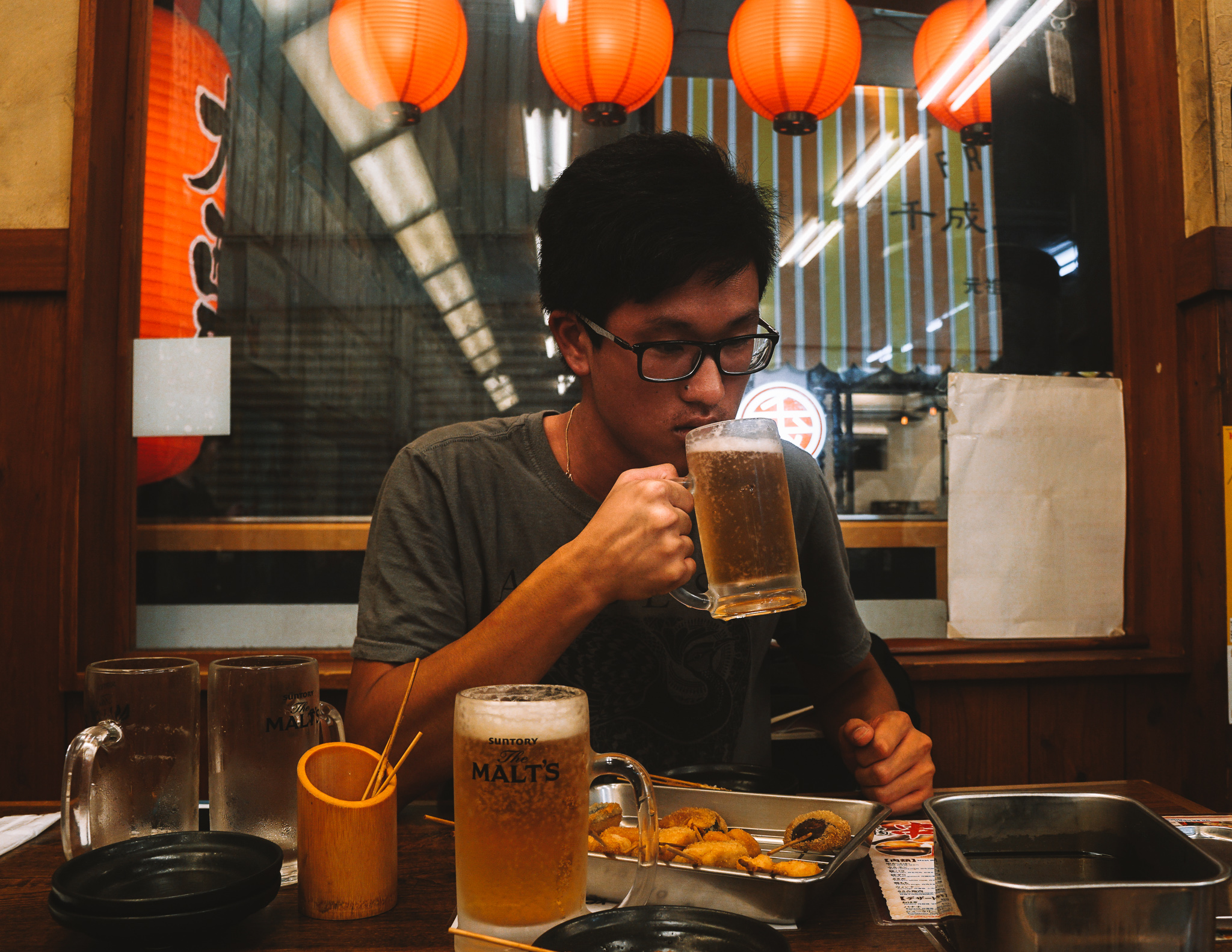 A man drinking beer in a Japanese restaurant