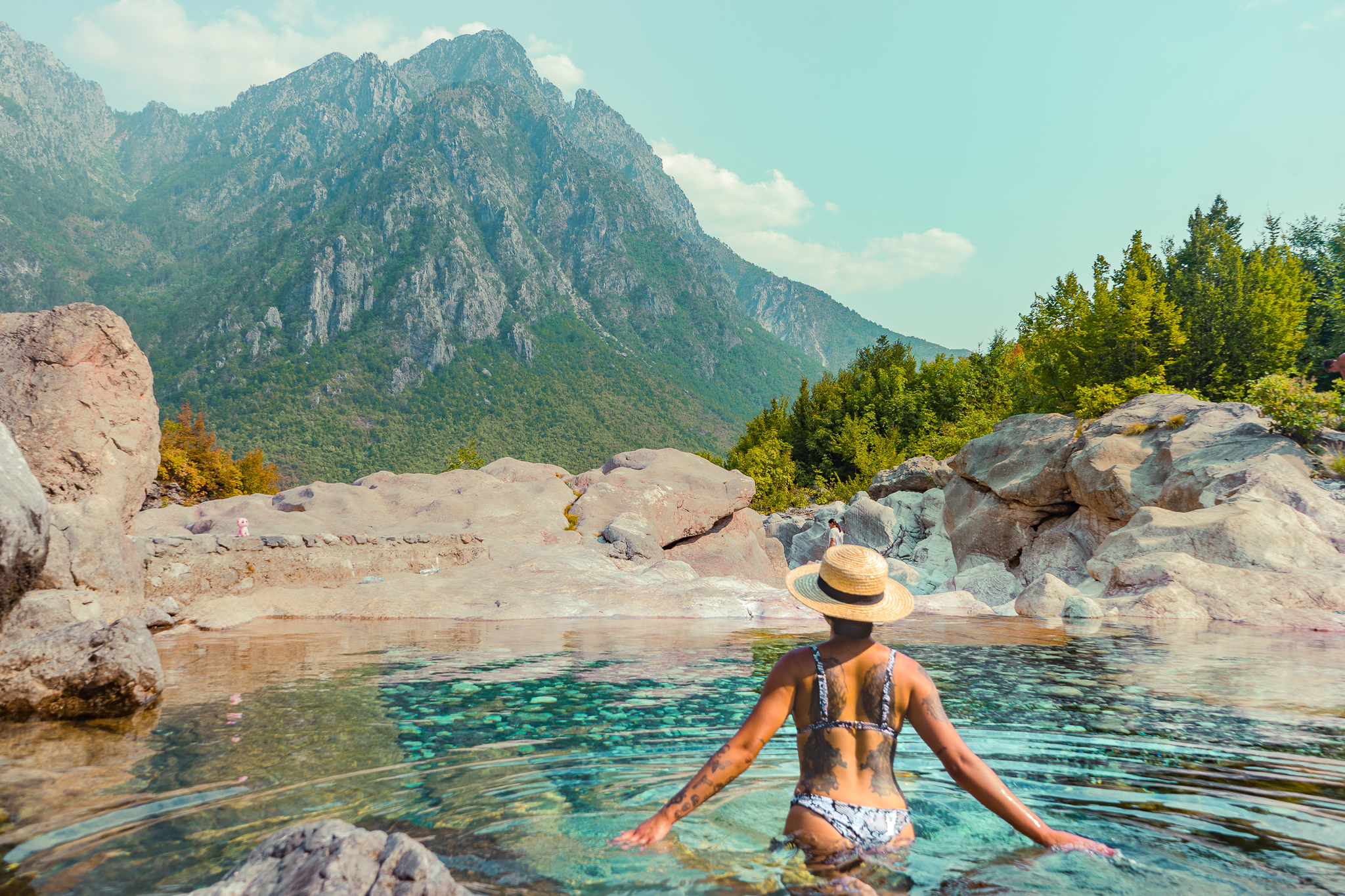 a girl in a water spring in the Albanian Alps near the Blue Eye Waterfall