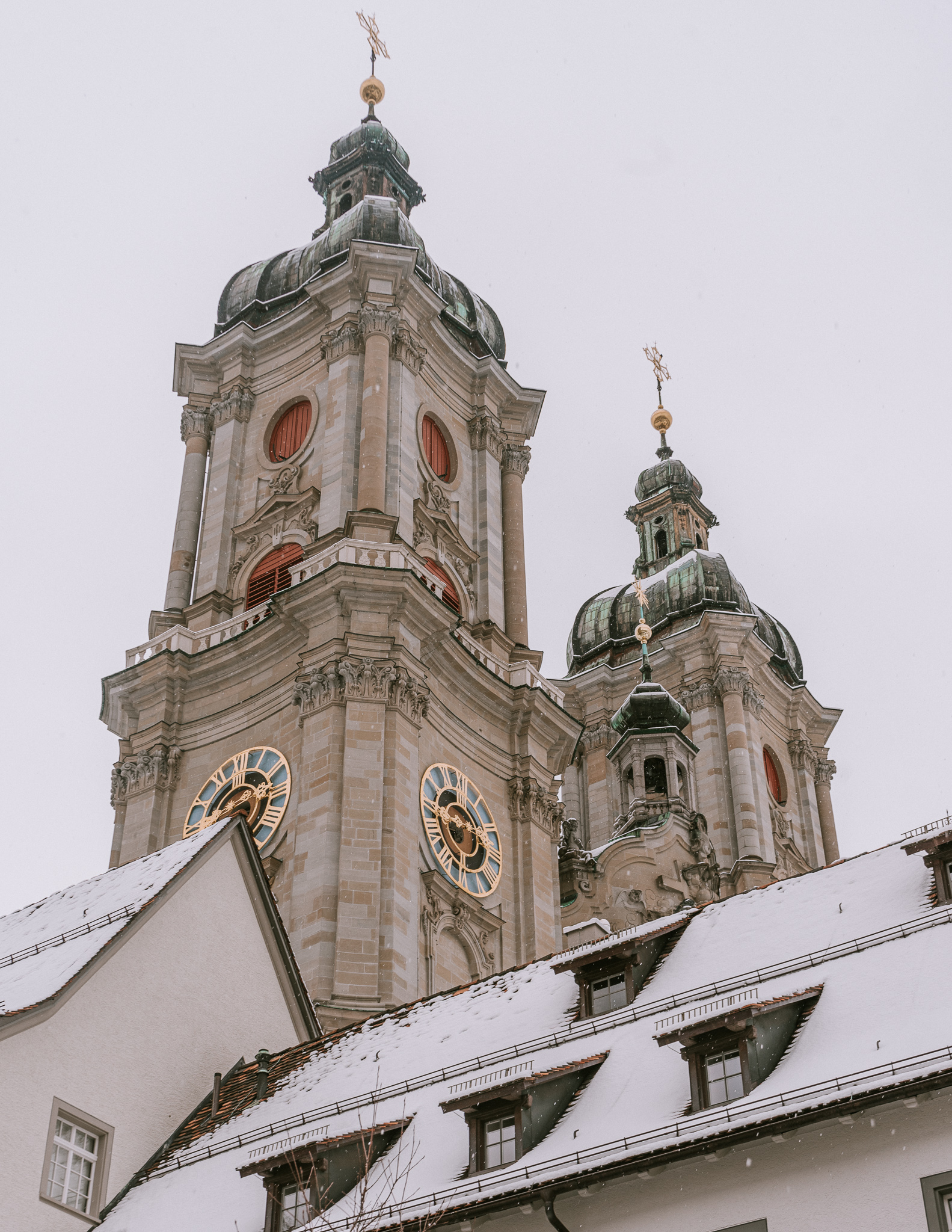 A view of the clocks and towers of St. Gallen Cathedral in winter