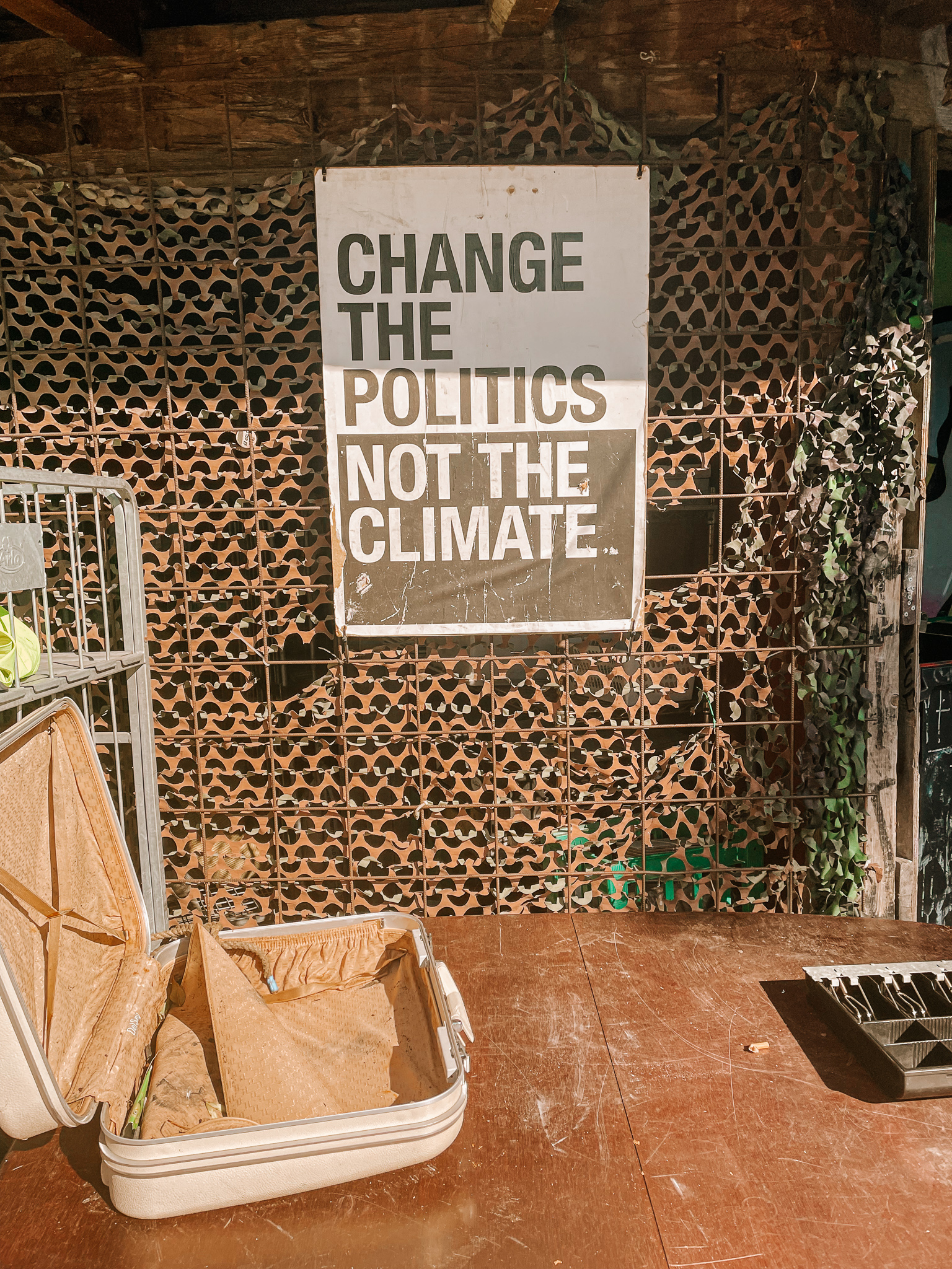 A black and white sign that says "change the politics not the climate" in Christiana Freetown, Copenhagen