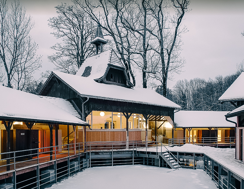 The Weiere sauna in winter with snow all over the roof and the lake frozen below.