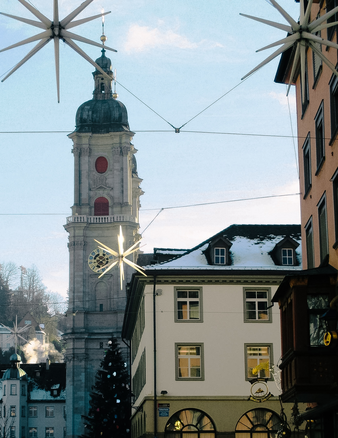 a view of St. Gallen catherdral in winter with christmas stars and decor in the square in front of it