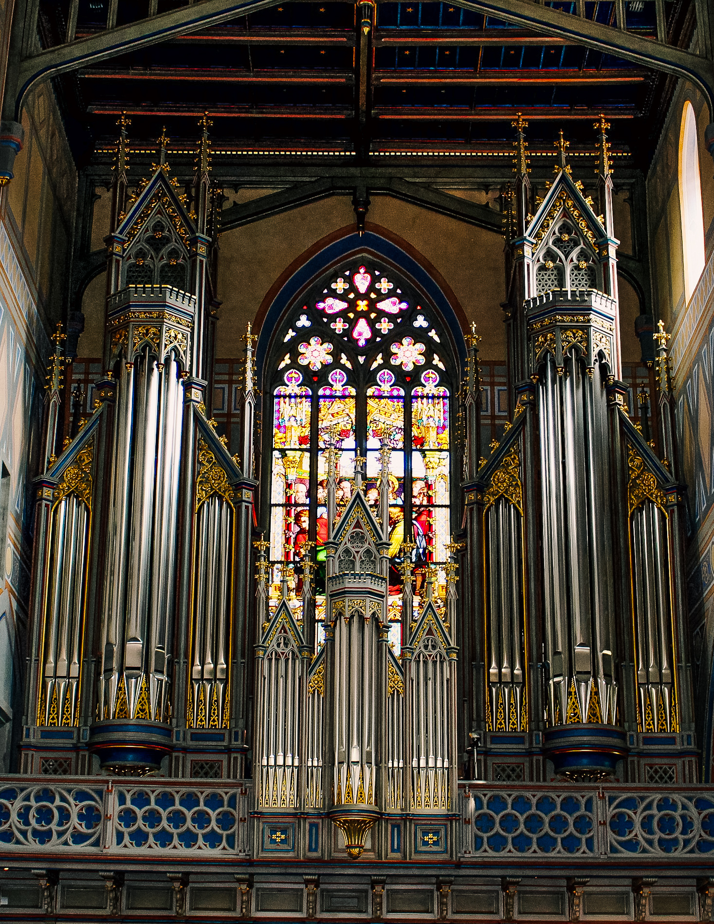 picture of the grand organ and stained glass windows inside St. Lawrence church.