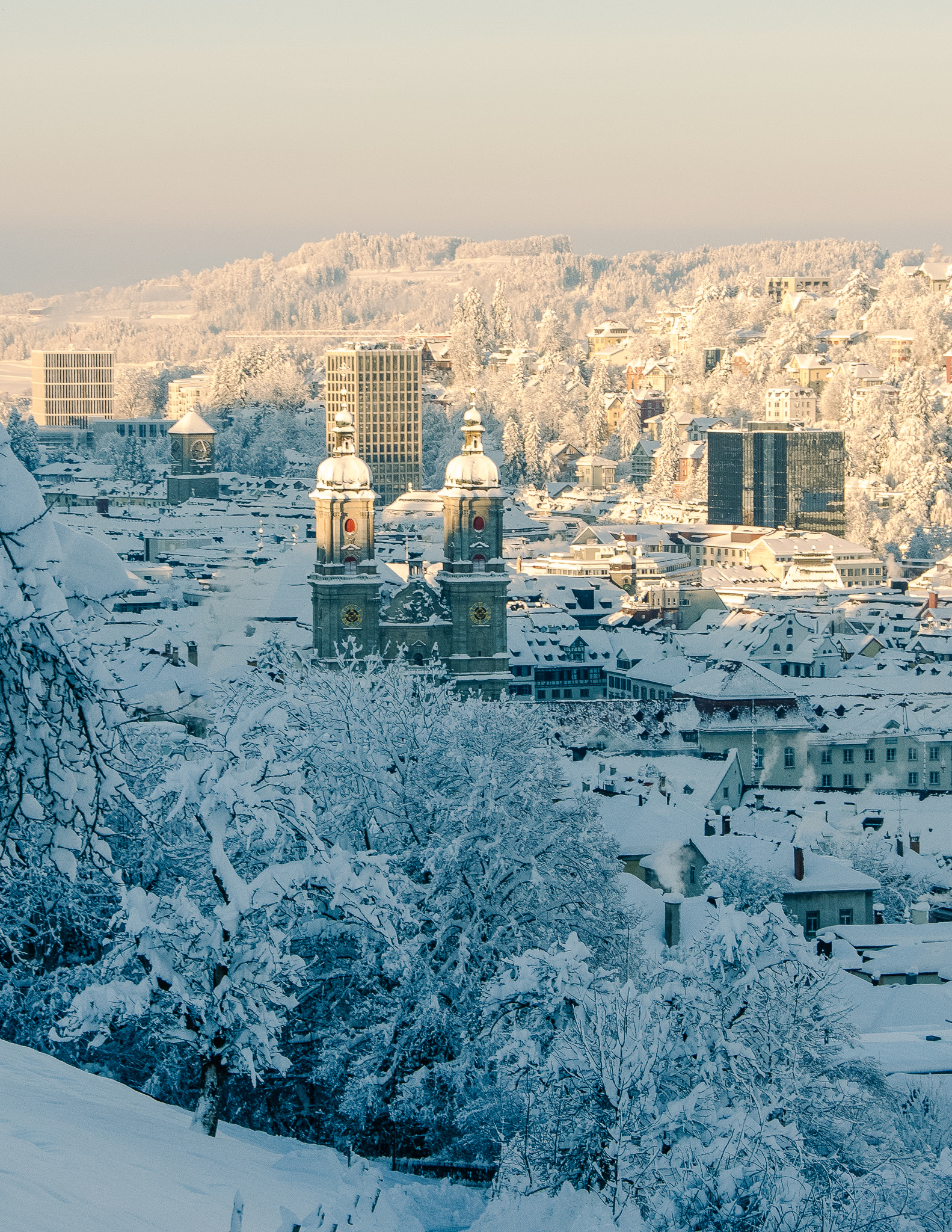 St. Gallen view from above, where the city is covered in snow with a view of the cathedral towers.