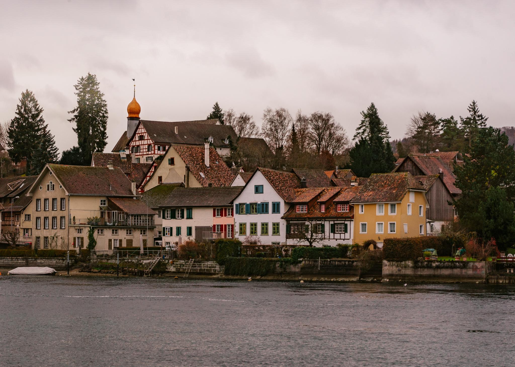 Swiss cottages across the Rhine river in Stein am Rhein in Switzerland on a cloudy, winter day.