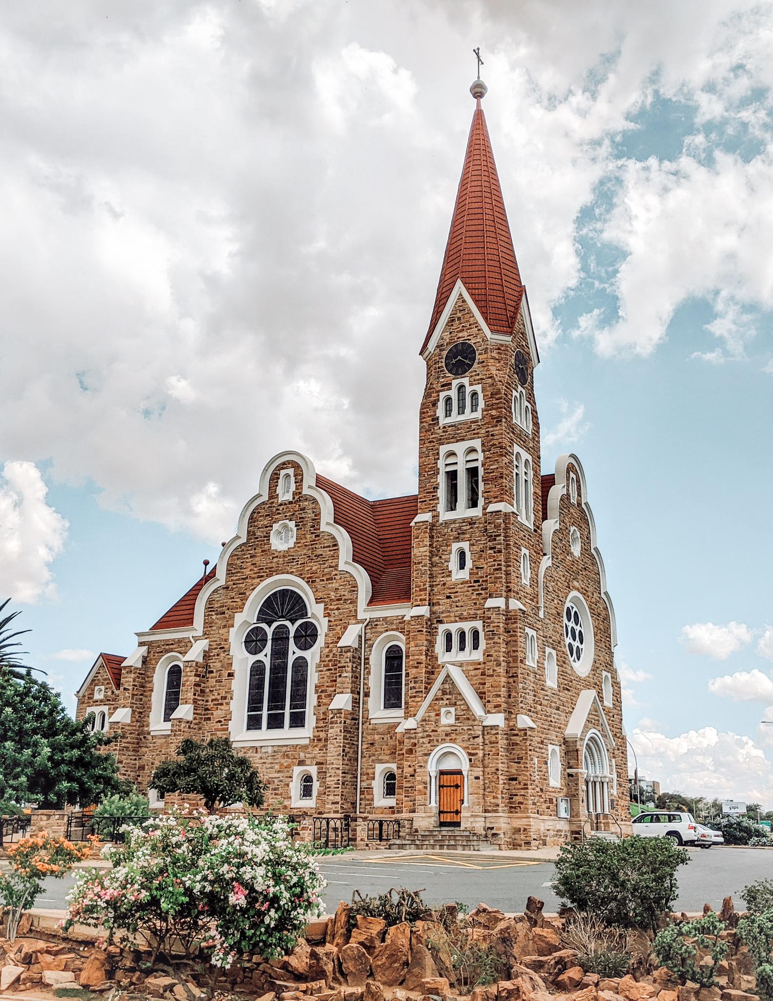 a brown brick church with a tall spire in Windhoek
