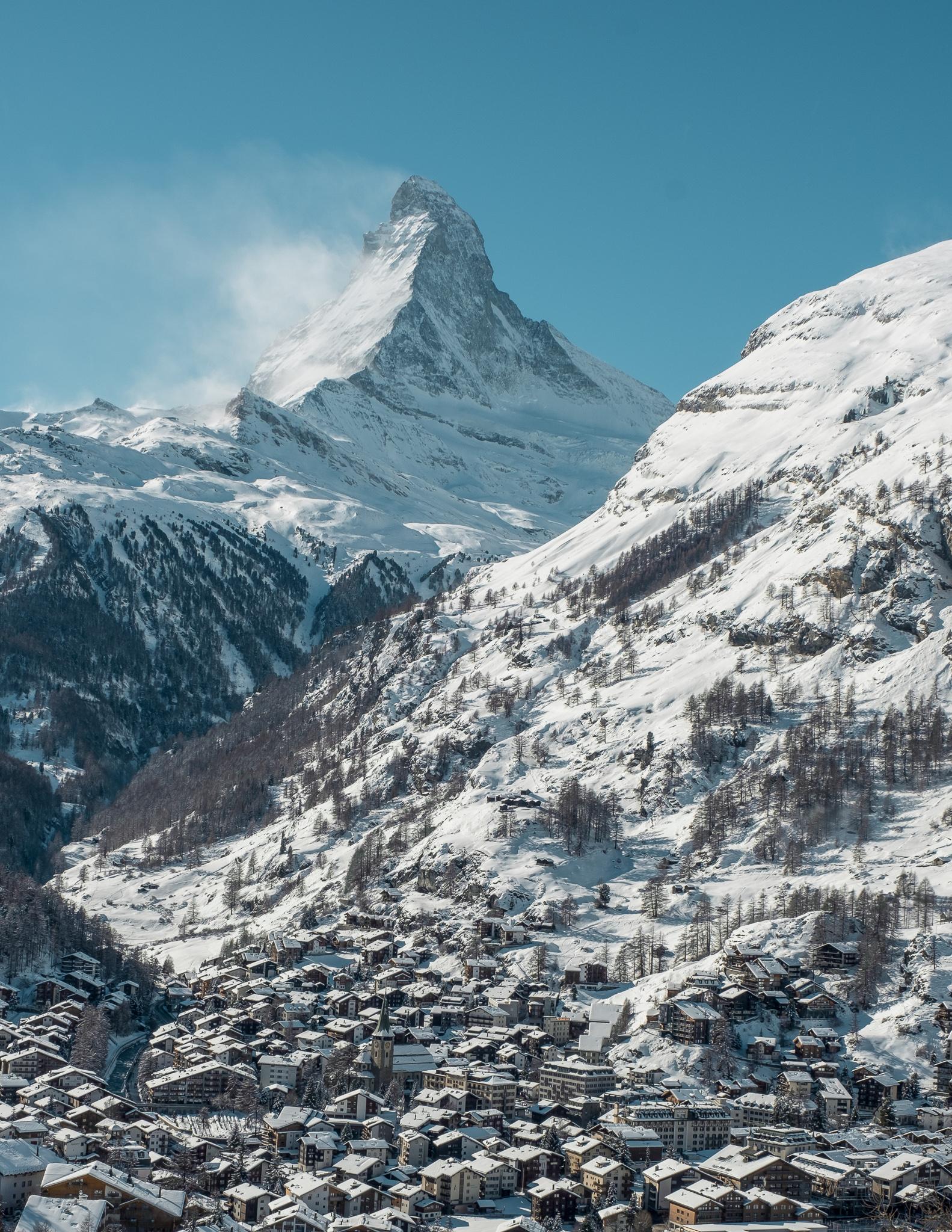 Matterhorn mountain on a clear, cloudless, sunny day with Zermatt village below and snow everywhere