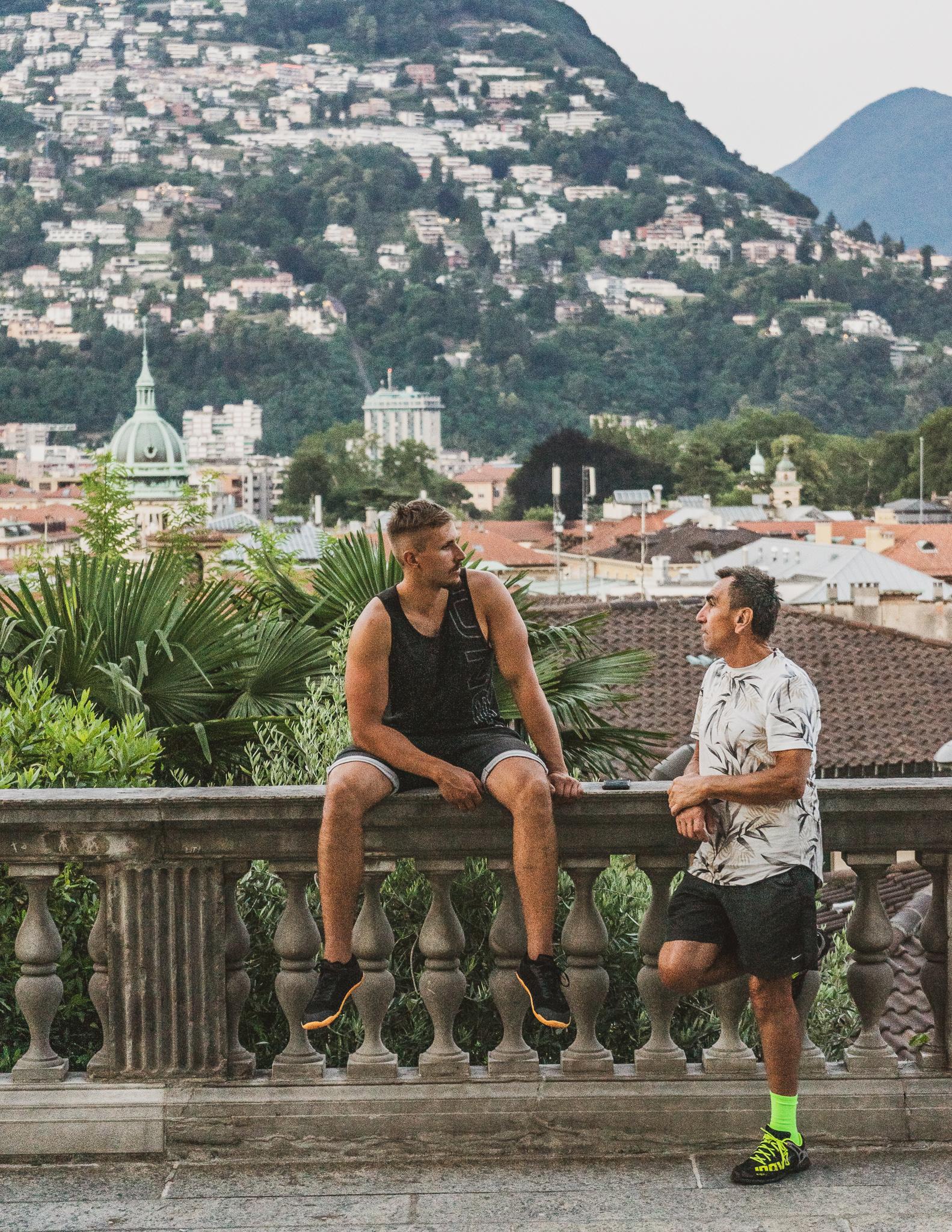 two men sitting on the plaza outside cathedral san lorezno in Lugano ticino switzerland