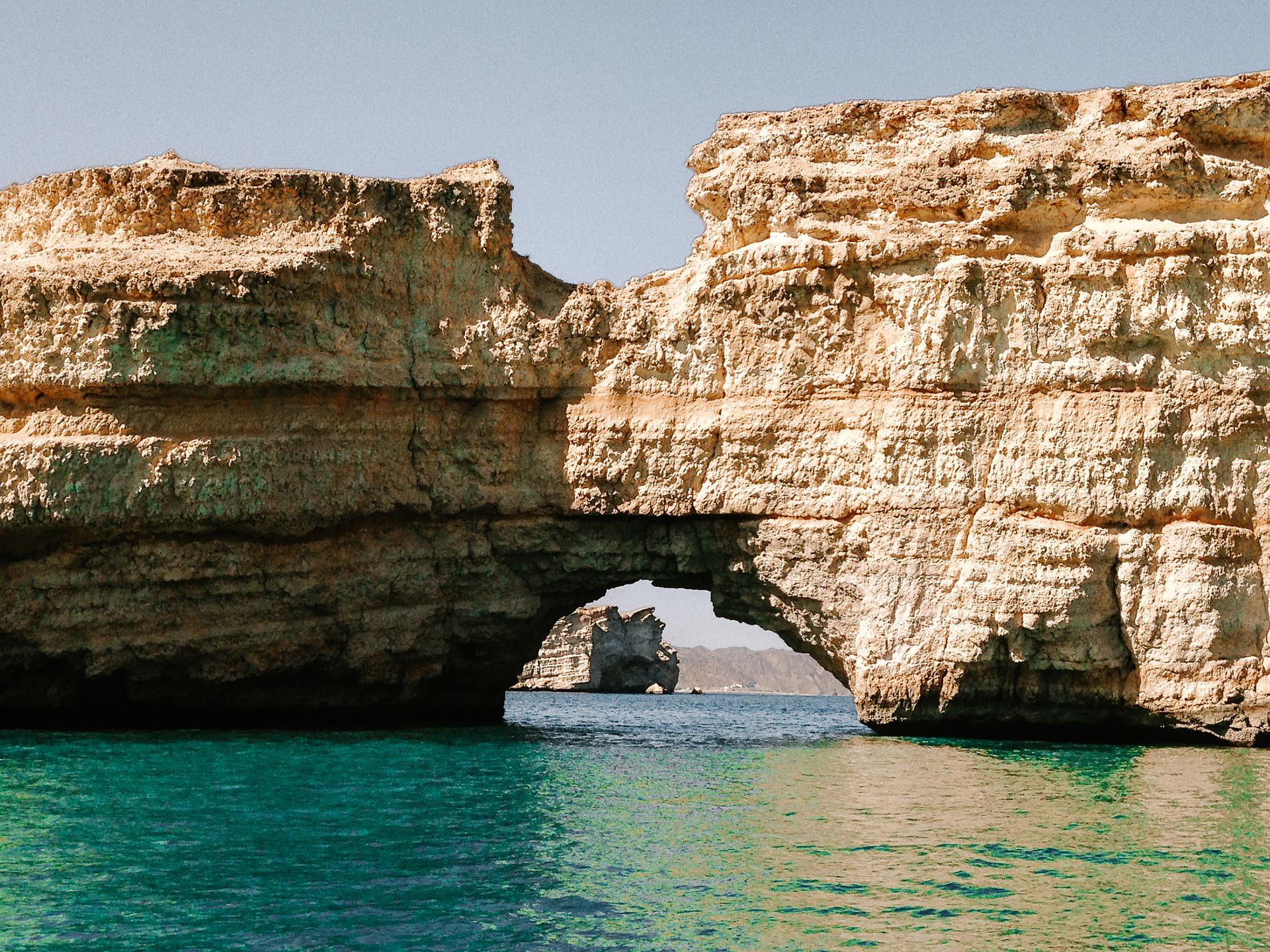 A rocky cliff with a hole underneath it in Oman