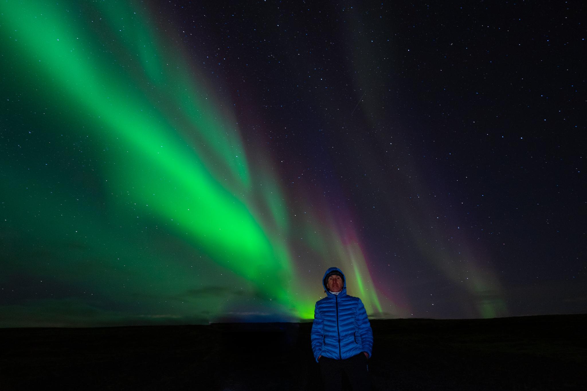 a man in front of the northern lights in Laugarvatn, Iceland