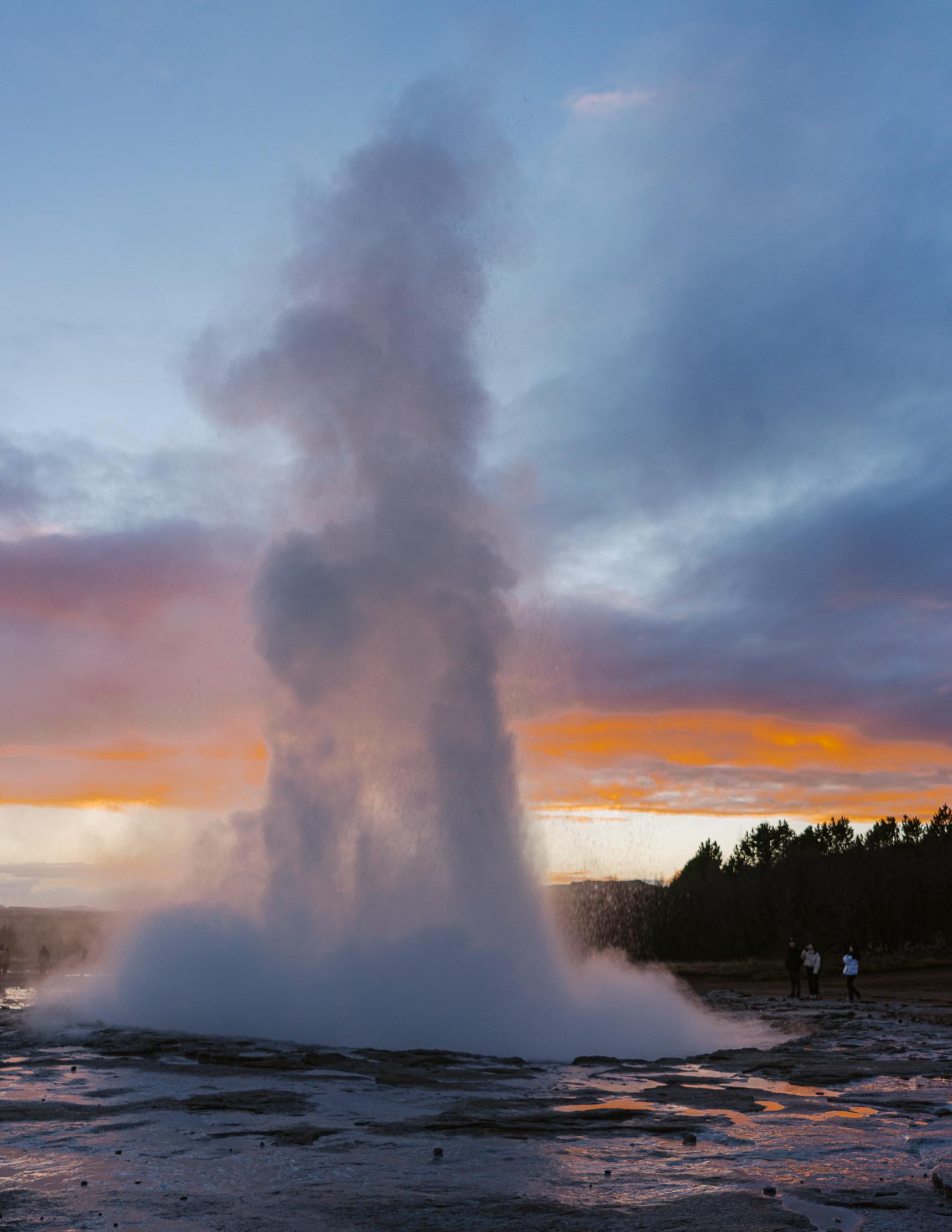water spouting from Geysir in Iceland at sunset