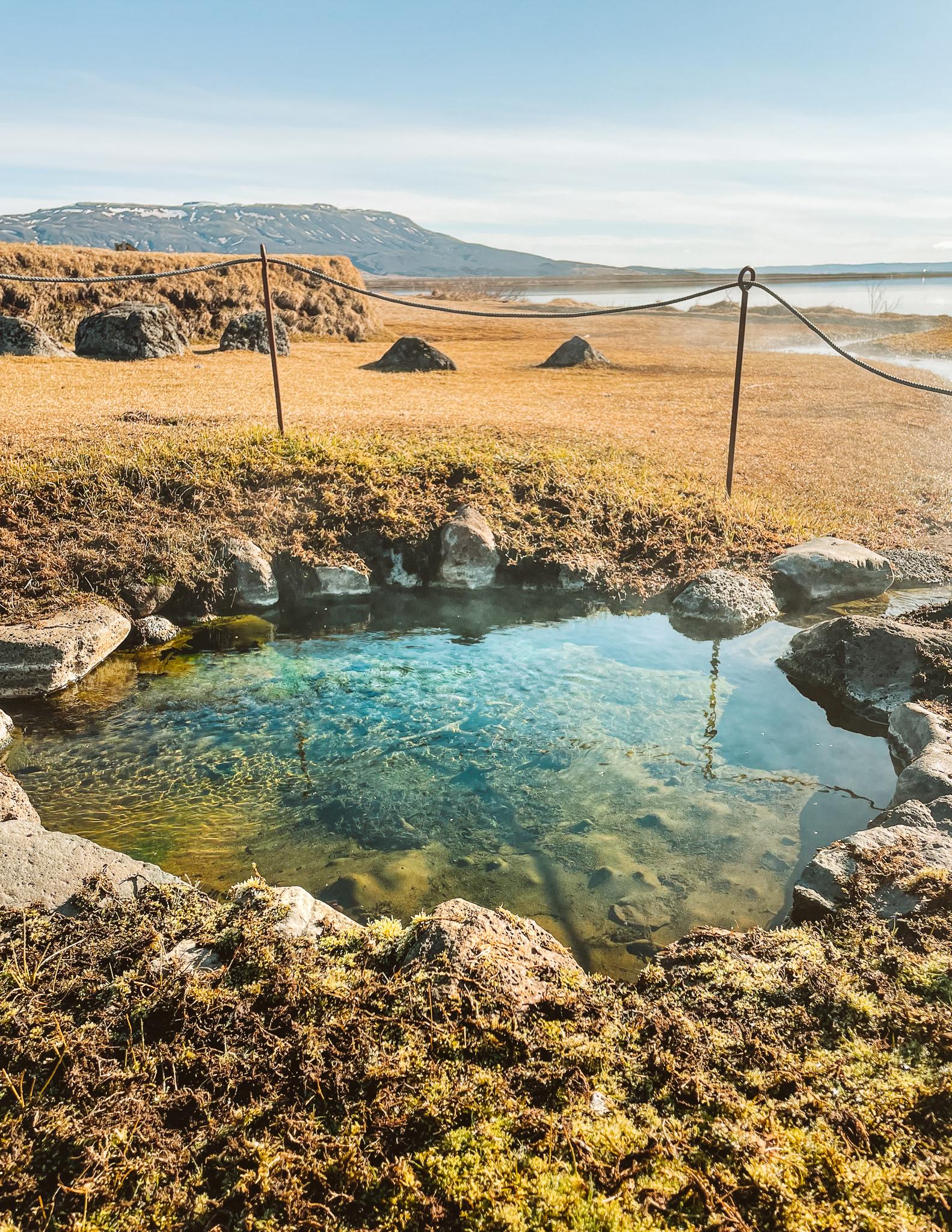 A natural hot pool in Laugervatn with the view of Laugarvatn Lake in Iceland