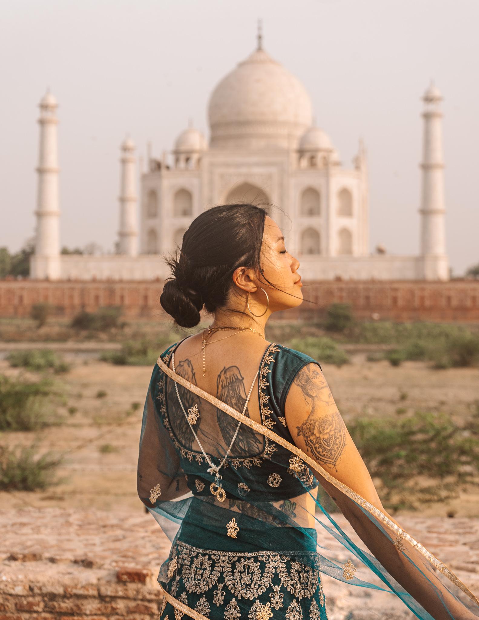 Girl in a traditional Indian dress in front of the Taj Mahal.