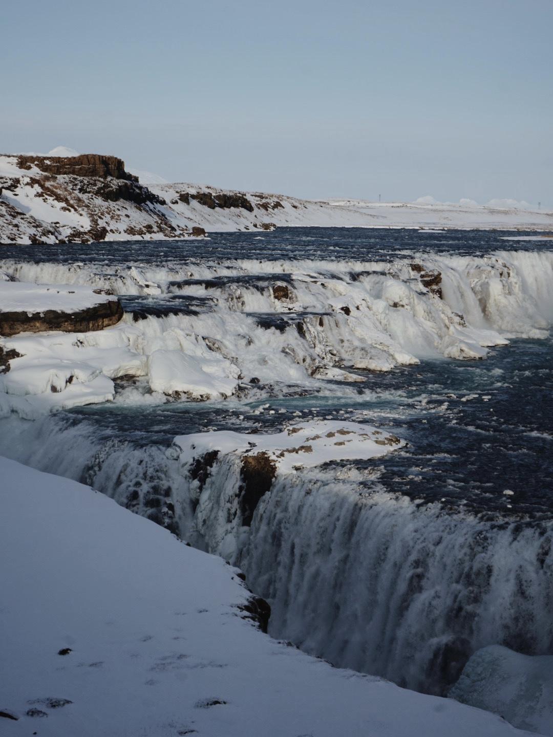 Gullfoss Waterfall in Iceland in winter with snow and ice surrounding the falls.