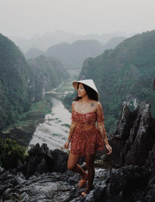 Vietnamese girl with a cone hat at a vewpoint in Trang An in Ninh Binh Province, Vietnam
